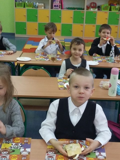 Uczniowie jedzą kanapki i sałatki
