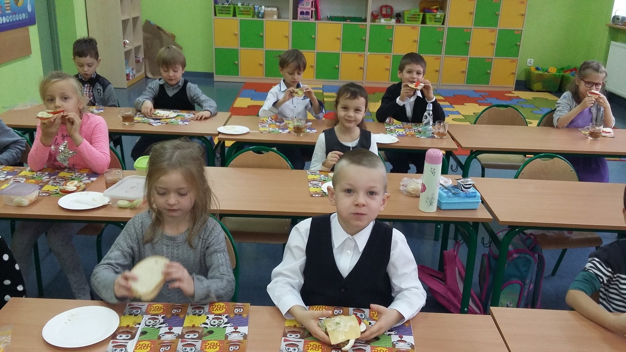 Uczniowie jedzą kanapki i sałatki