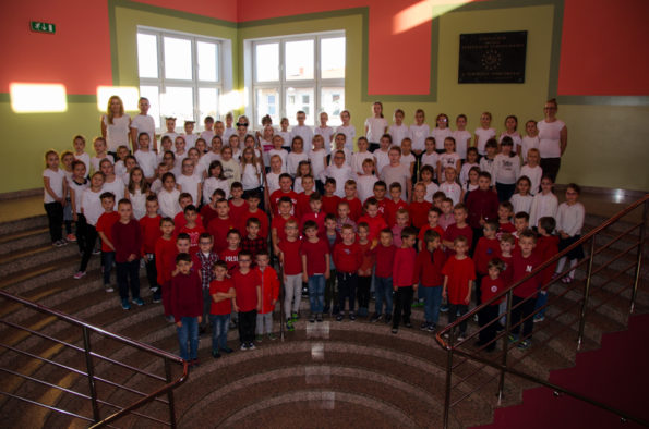 Uczniowie na schodach. Kolory koszulek układają się we flagę Polski.